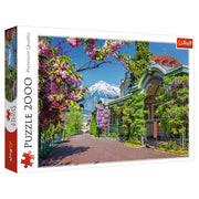 Merano, Italy 2000 Piece Puzzle - 2000-piece puzzle box featuring vibrant Merano, Italy scene with flowering trees, mountain backdrop, and historic buildings.