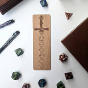 Dice Sword Wooden Bookmark - Wooden bookmark engraved with a sword and stacked polyhedral dice designs.