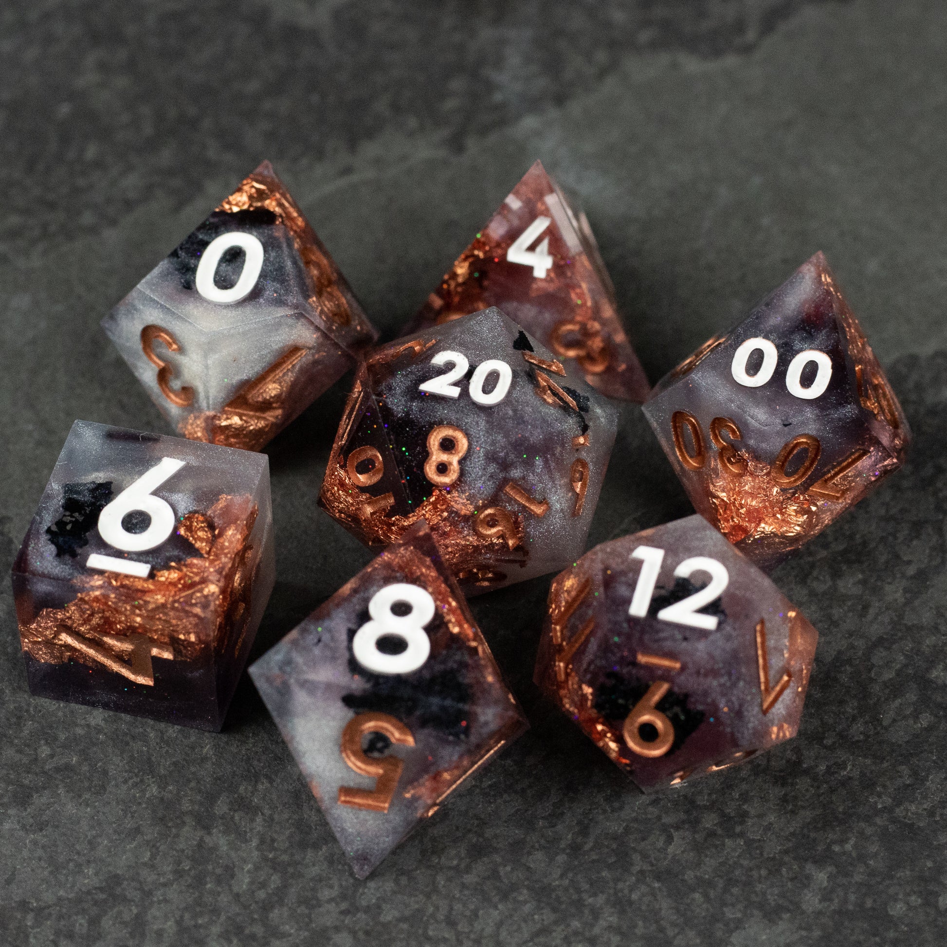 Lich King Dice Set - Seven dark translucent polyhedral dice with sharp edges and copper-colored metallic inclusions, white numbering.