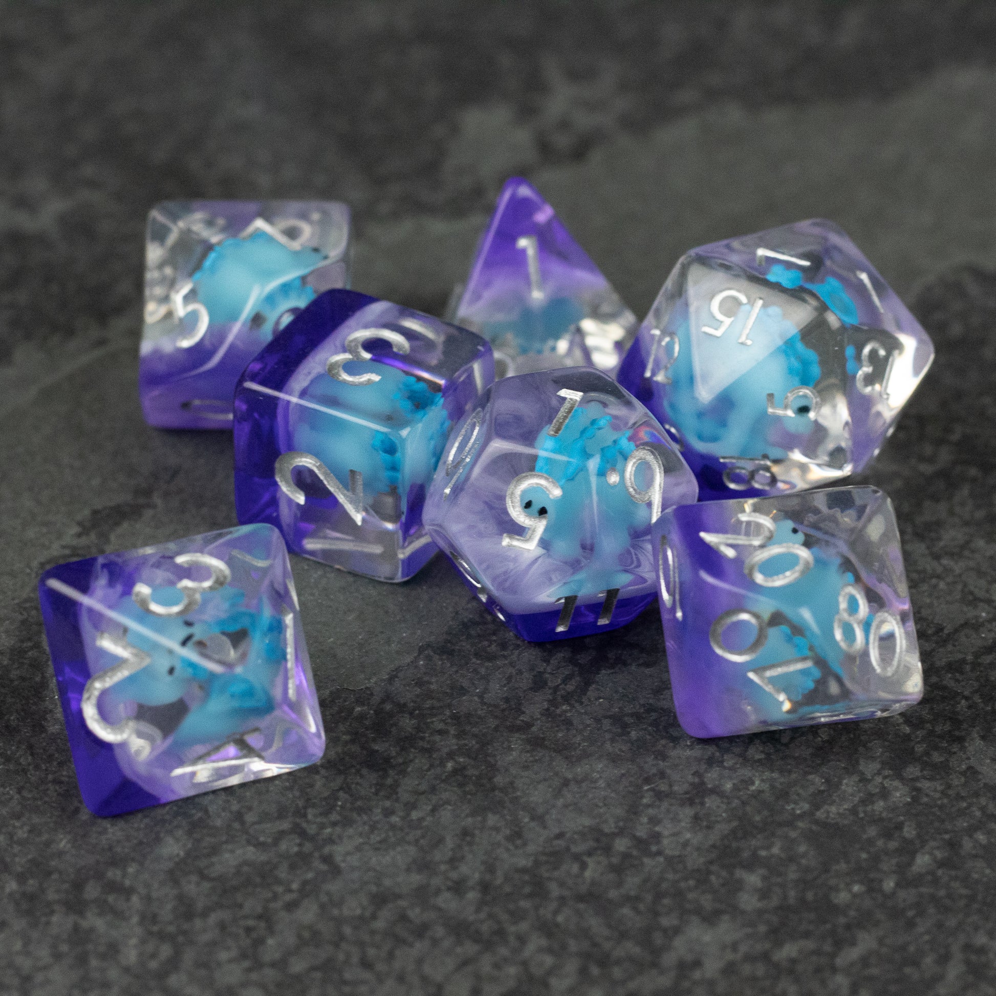 Blue Stegosaurus Dice Set - Translucent purple and blue polyhedral dice set with white numbers, including a visible stegosaurus design inside.