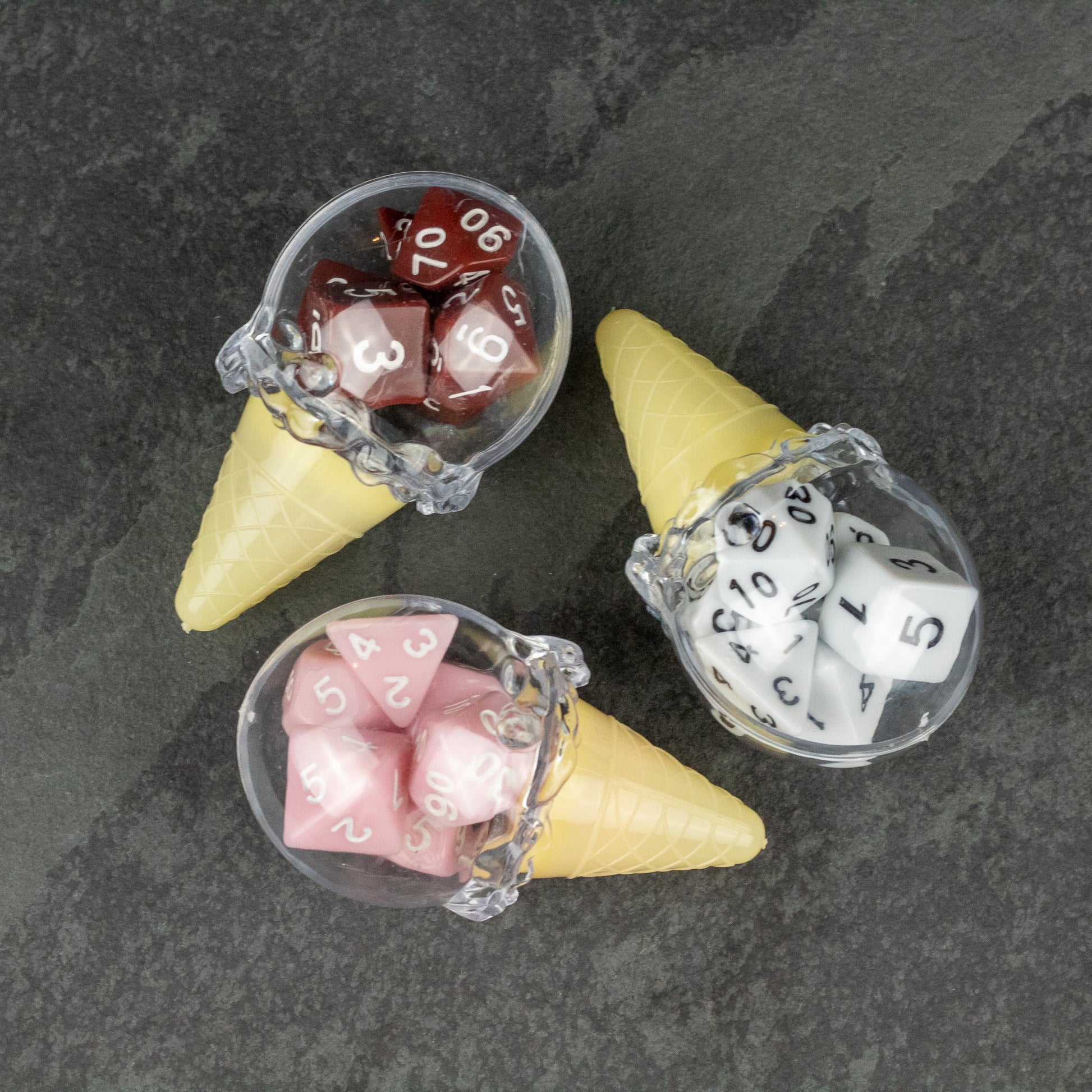 Dice Cream Cones - Three plastic ice cream cones filled with multi-sided dice in red, white, and pink colors with white numbering.