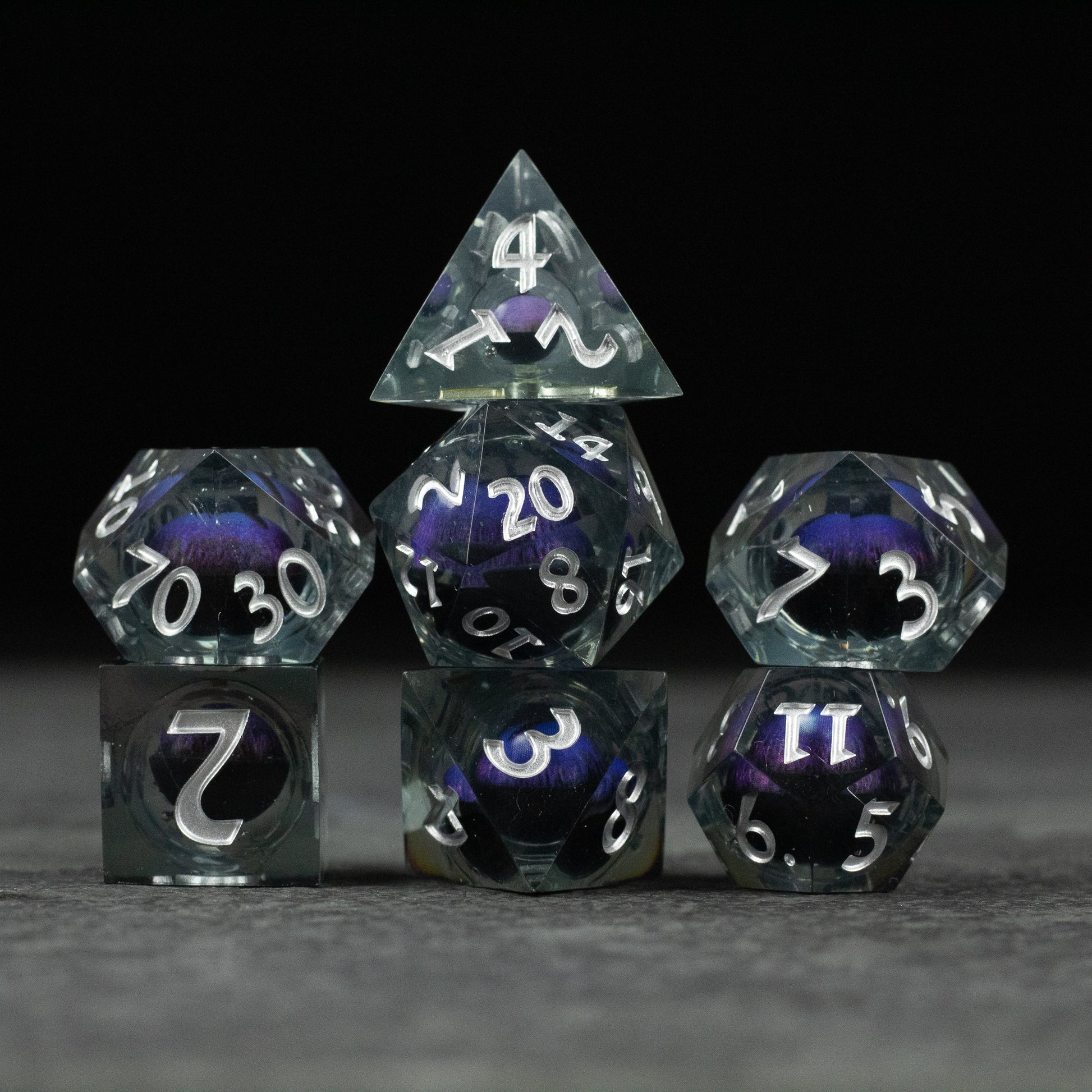 Purple Beholder's Eye Dice Set - Seven transparent purple polyhedral dice with sharp edges and white numbering, featuring a marbled liquid core design.