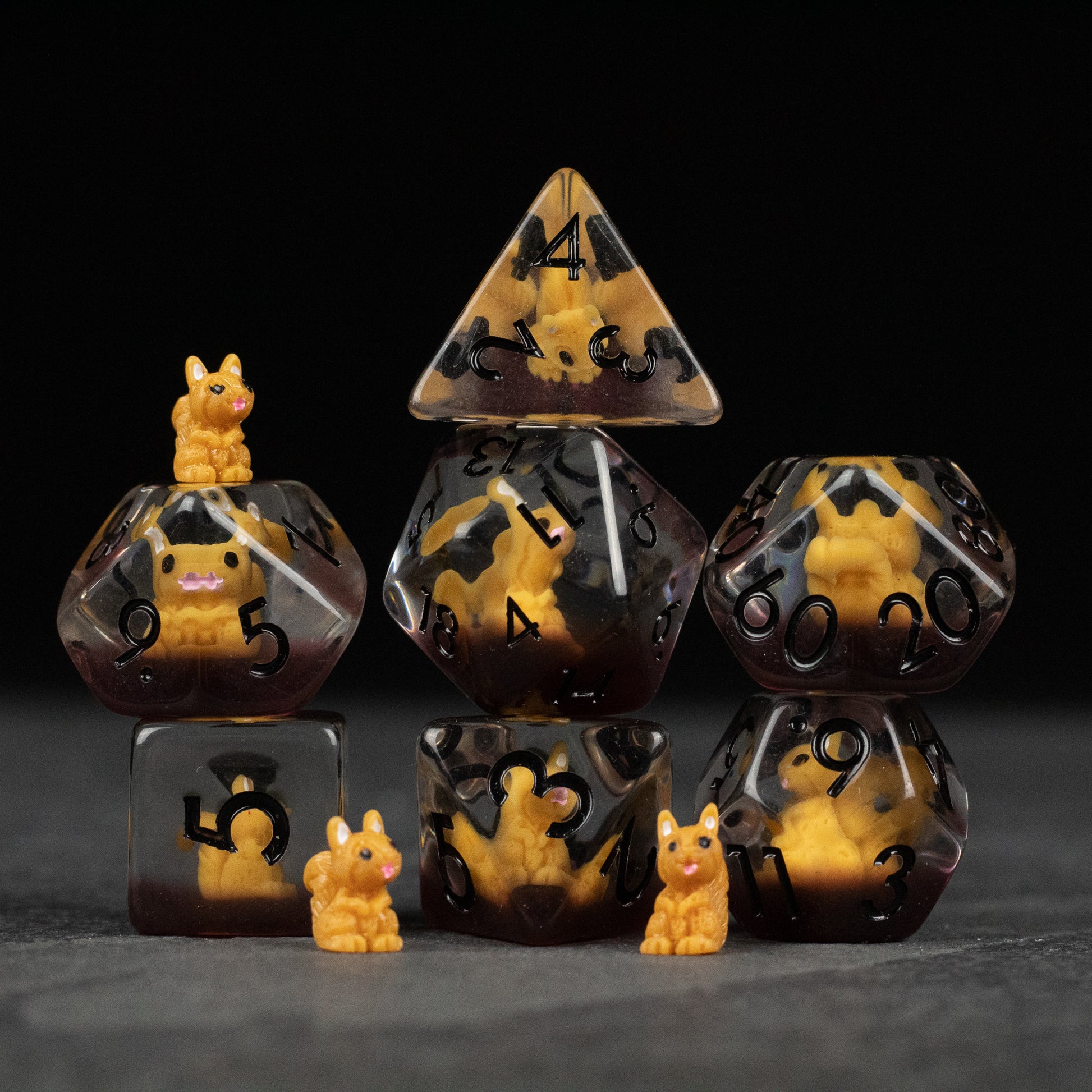 Squirrel Dice Set - Set of seven brown and yellow marbled polyhedral dice with black numbers, each featuring small orange squirrel figurines on.