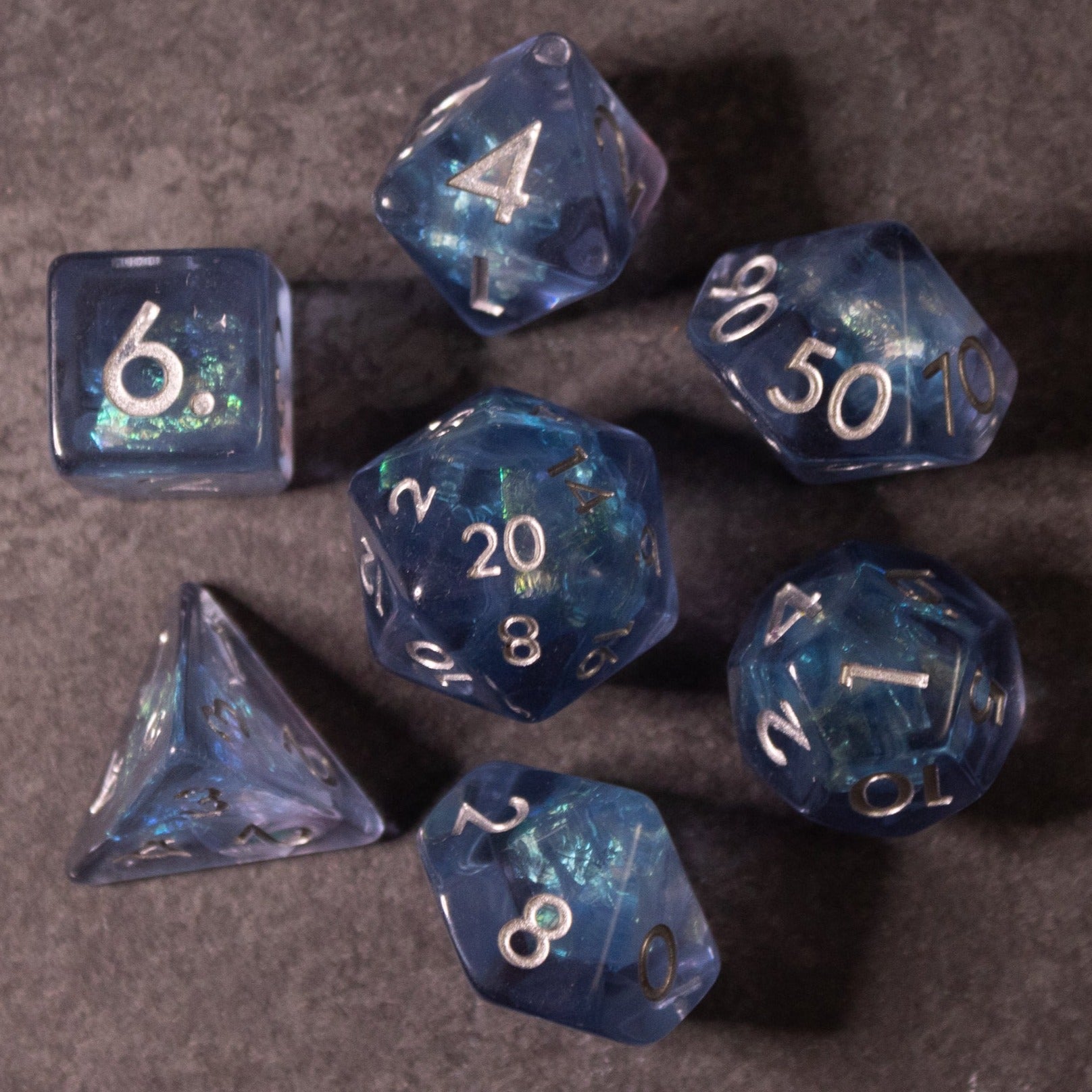 Glacier Ice Dice Set - Set of seven translucent blue polyhedral dice with iridescent swirls and white numbering, including d4, d6, d8, d10, d12,.