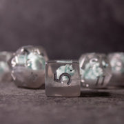 Dinosaur Dice Set - Triceratops - Clear resin dice with embedded light blue and white Triceratops dinosaur figures and black numbering.