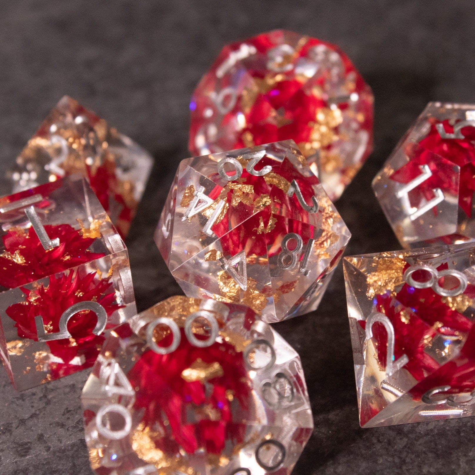 Red Lotus Flower Dice Set - Clear polyhedral dice with sharp edges featuring red lotus flower designs inside and white numbering.