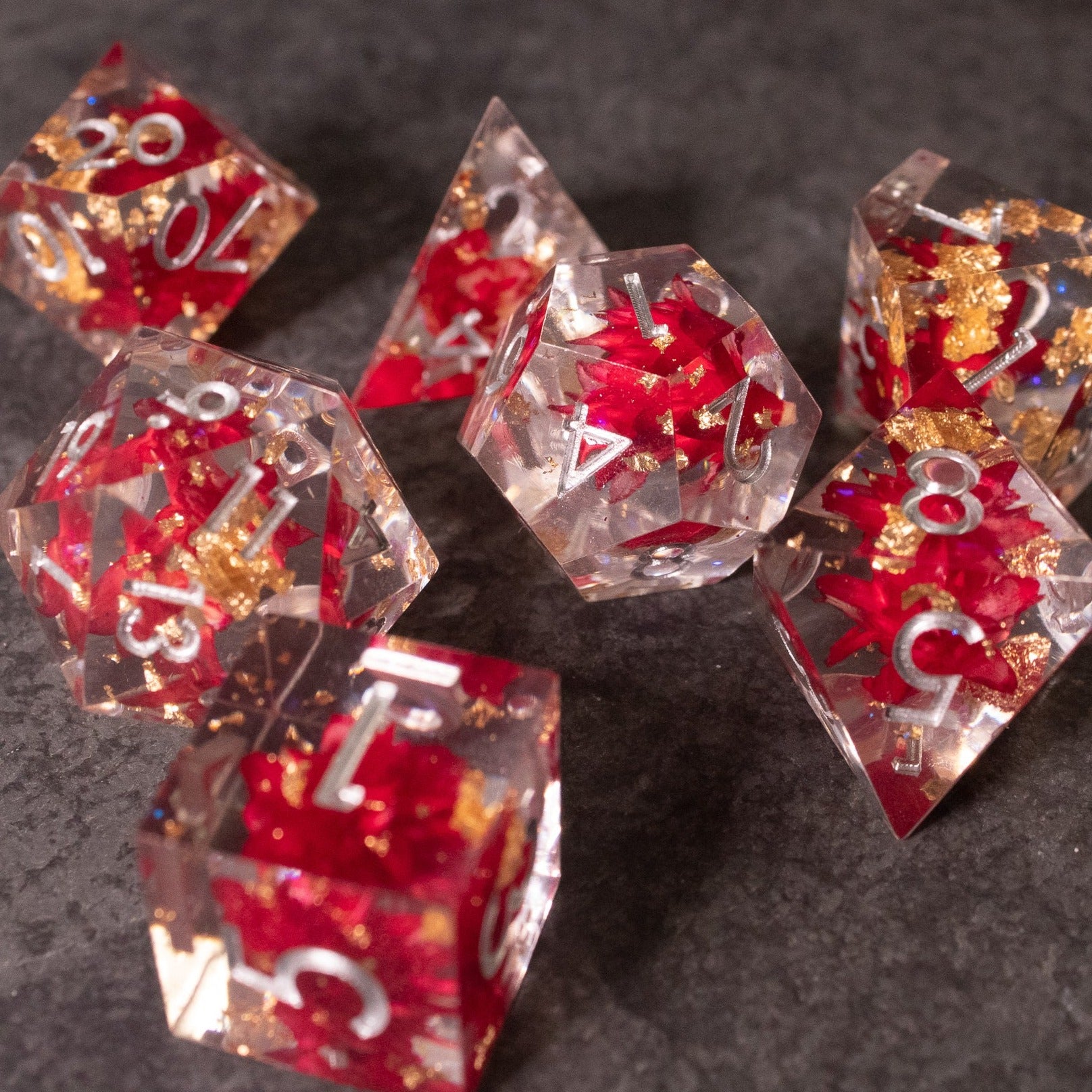 Red Lotus Flower Dice Set - Clear sharp-edged dice with red lotus flower designs and gold numbering on each face.