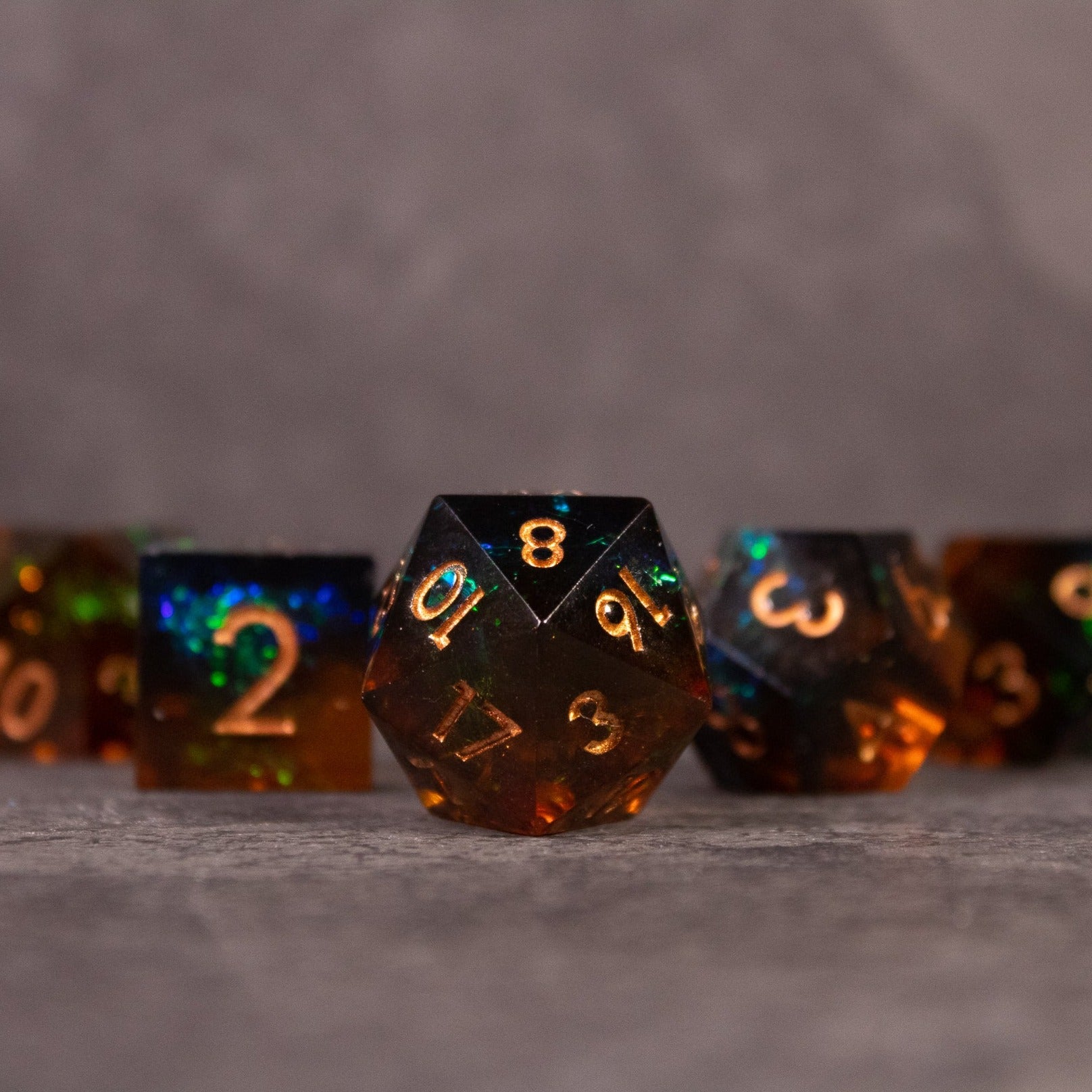 Whiskeyjack Dice Set - Black translucent sharp-edged dice set with orange numbers, featuring a 20-sided die in front.