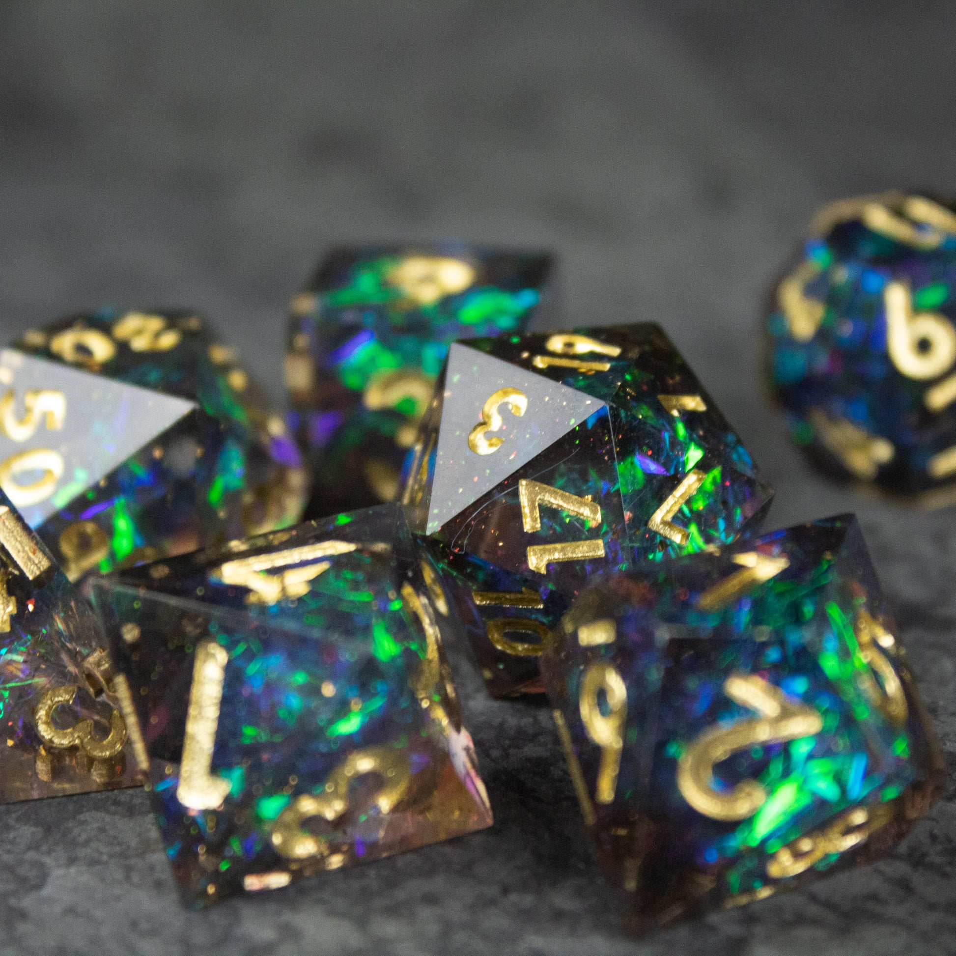 Galaxy Dice Set - Set of black sharp-edged dice with iridescent galaxy-style colors and gold numbering.