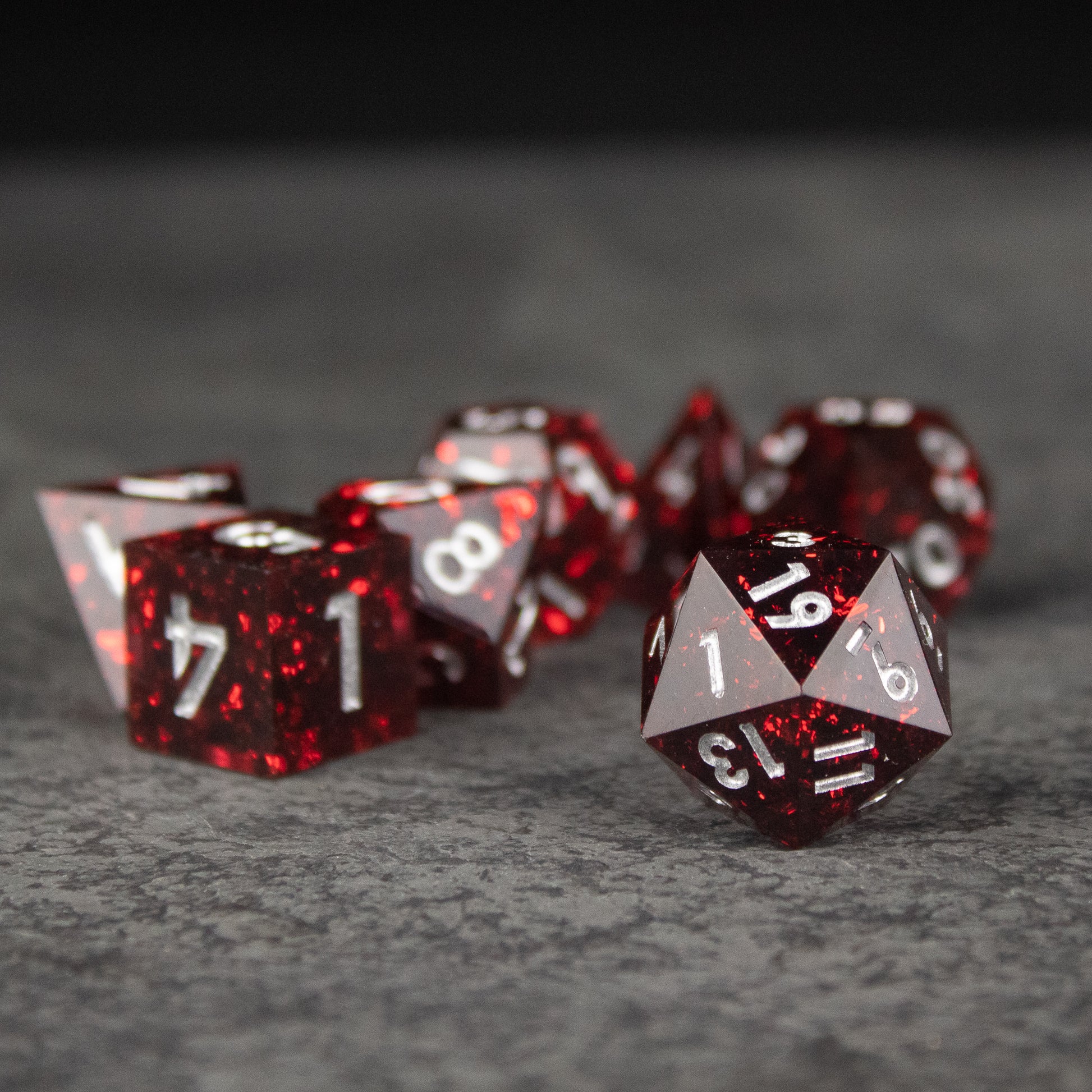 Inferno Dice Set - Glossy red polyhedral dice set with sharp edges and white numbers on each face.