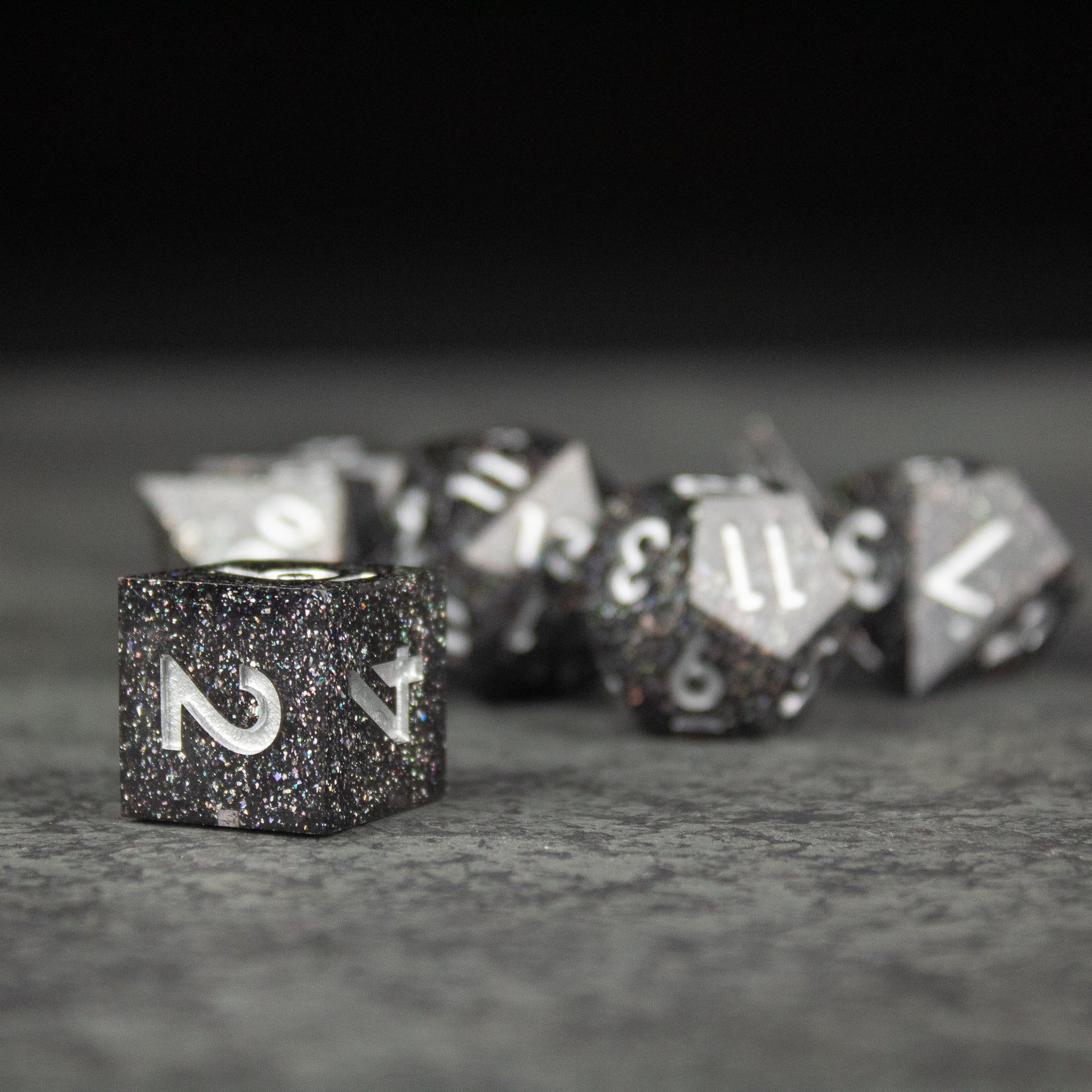 Starfield Dice Set - Black and silver glitter sharp-edged polyhedral dice set with white numbering for tabletop games.