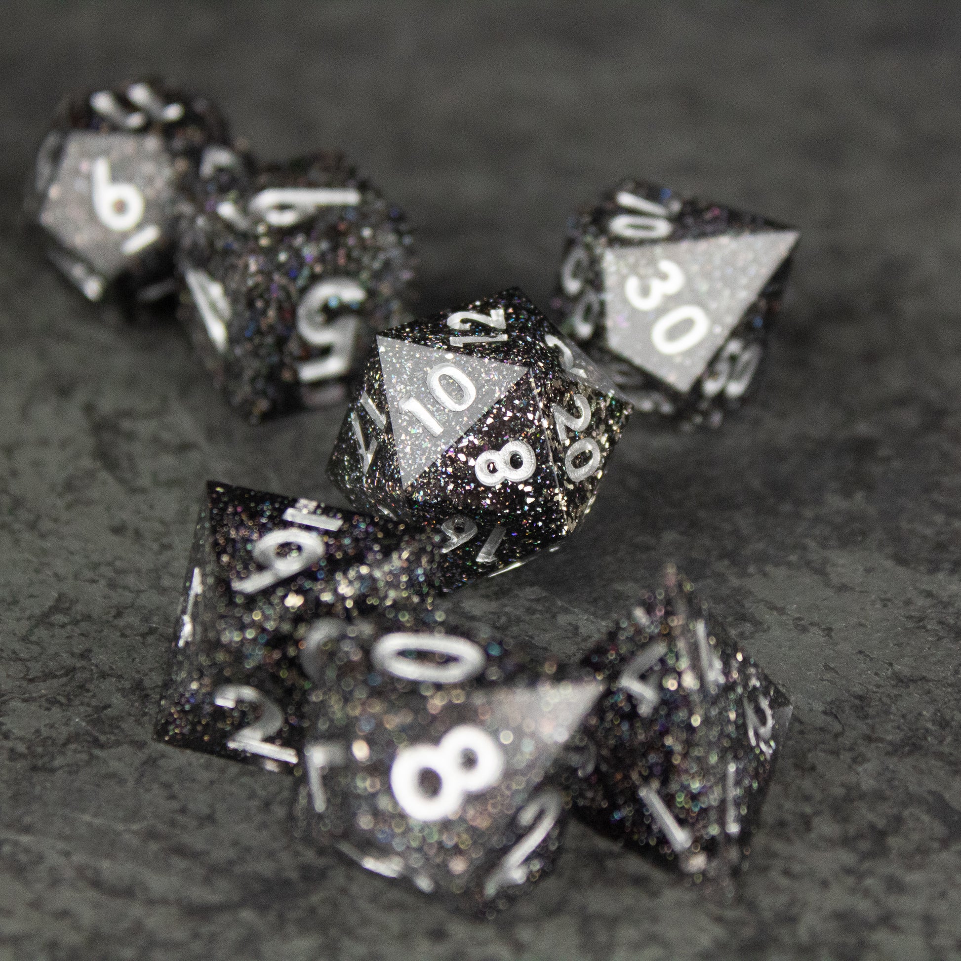Starfield Dice Set - Glossy black polyhedral dice set with silver numbers and silver glitter flecks inside, sharp edges.