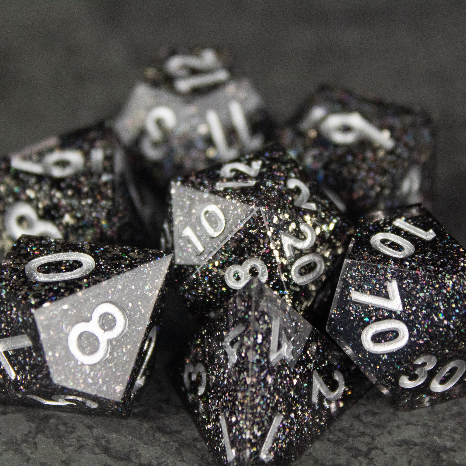 Starfield Dice Set - Black polyhedral dice set with white numbers and glittery star-like specks resembling a starry night sky.