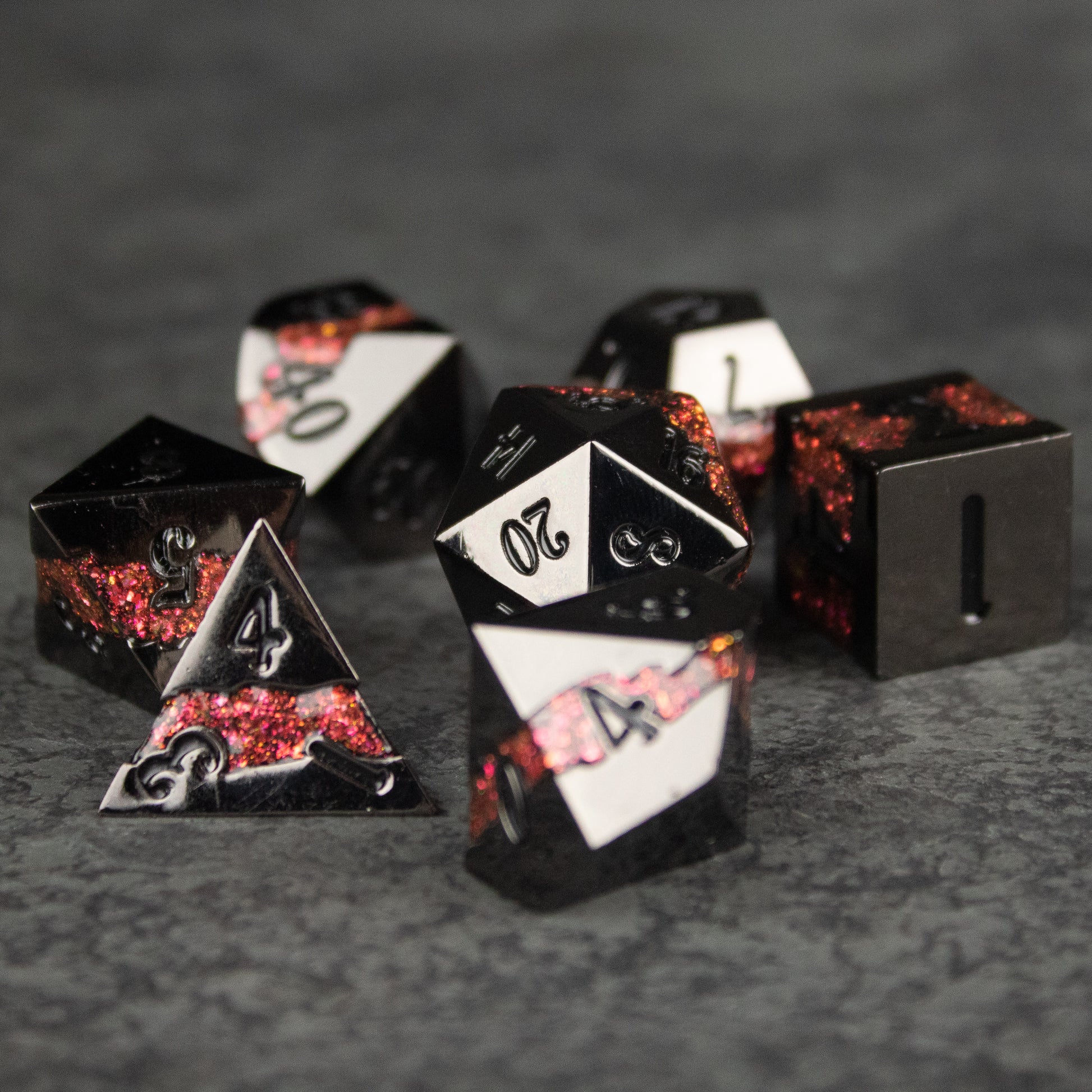 Red Rift Metal Dice Set - Set of black and red metal polyhedral dice with white numbering, featuring a smoky, marbled red design inside each die.