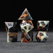Dwarven Delight Dice Set - Sharp-edged black and white Dwarven Delight polyhedral dice with smoky, burnt orange accents.