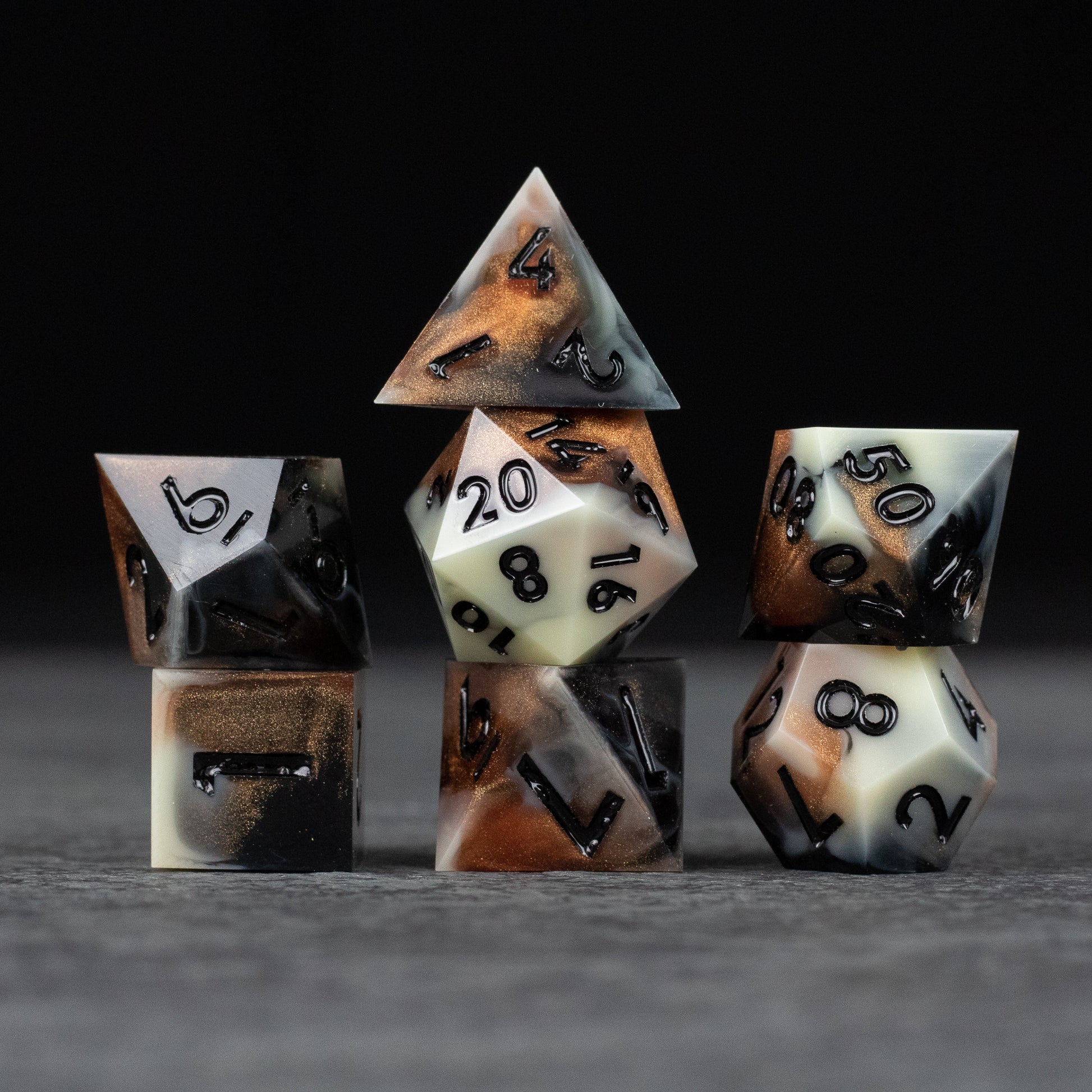 Dwarven Delight Dice Set - Sharp-edged black and white Dwarven Delight polyhedral dice with smoky, burnt orange accents.
