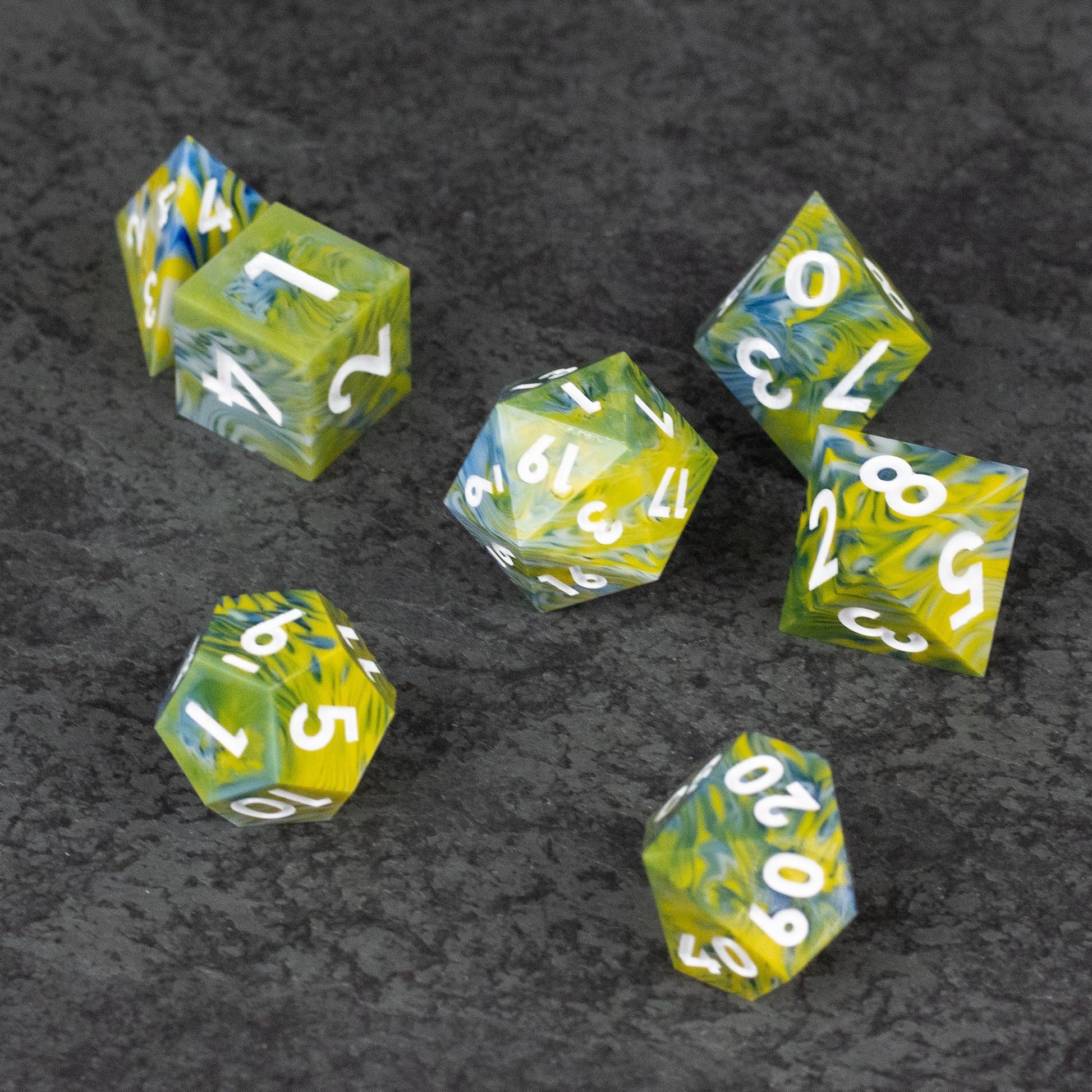 Acid Splash Dice Set - Set of seven transparent green and yellow sharp-edged polyhedral dice with white numbers on black textured surface.