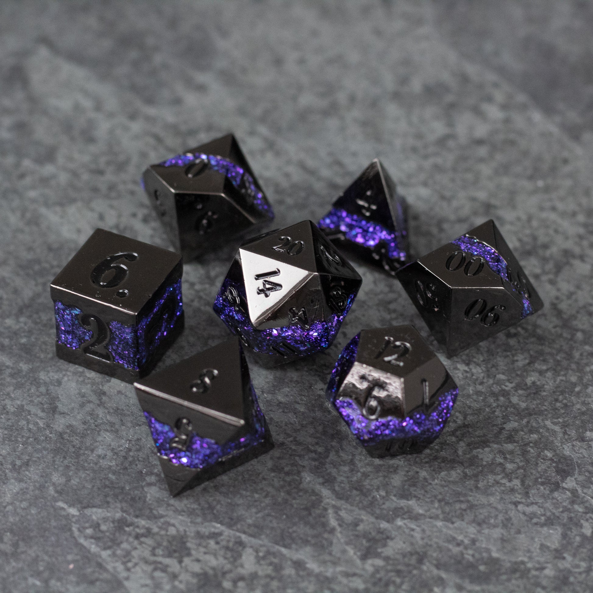 Purple Rift Dice Set - Set of black metal polyhedral dice with purple glitter accents on gray textured background.