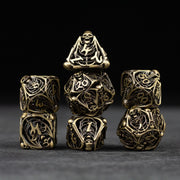 Bone Crypt Dice Set - Set of seven hollow metal dice in black and gold with intricate bone and crypt-inspired designs.