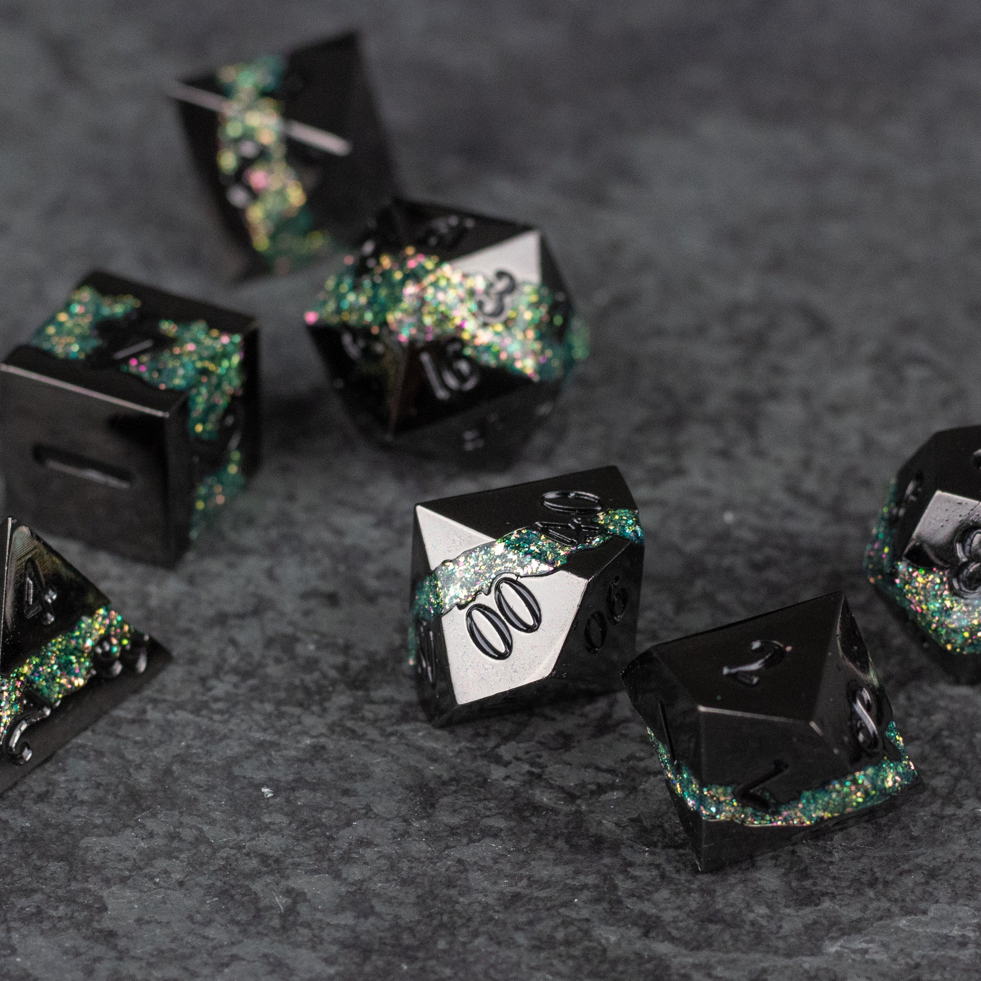 Light Green Rift Dice Set - Black and light green metal dice set with iridescent glitter accents and sharp edges on a dark gray surface.
