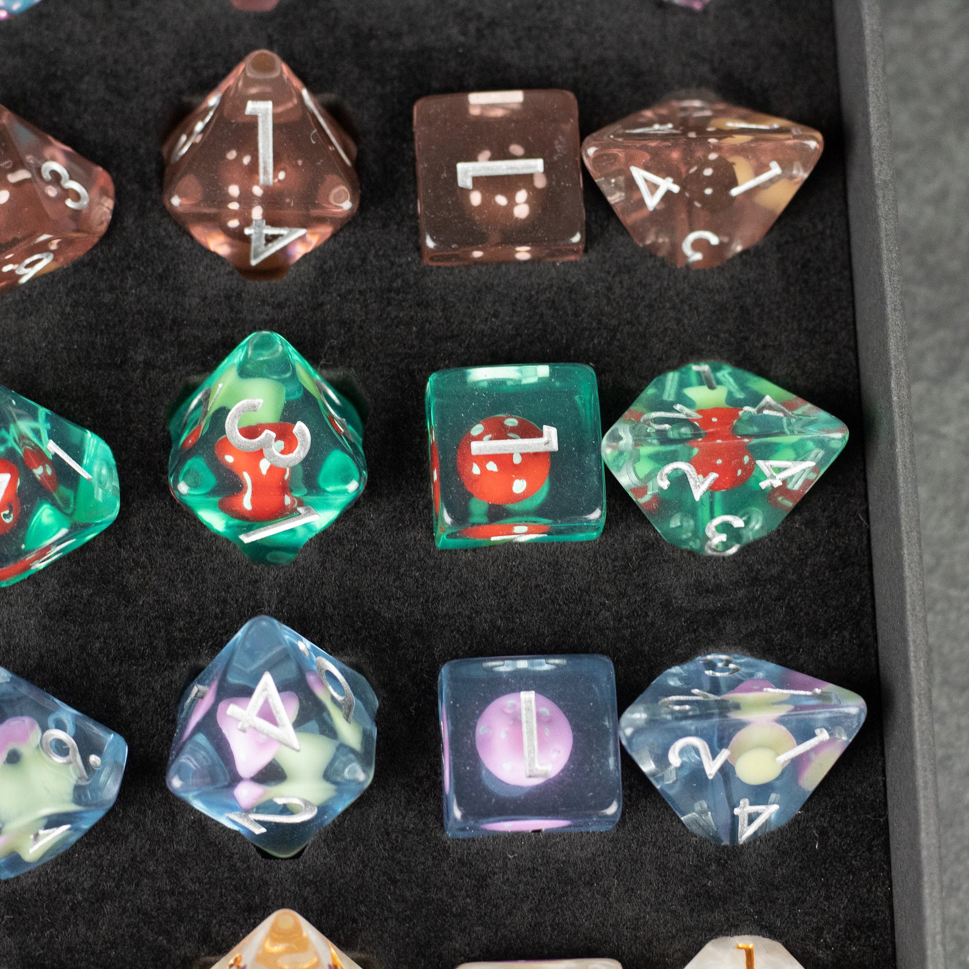 Mushroom Dice Set Gift Box - Set of translucent polyhedral dice in brown, green, and blue with mushroom-themed designs inside.