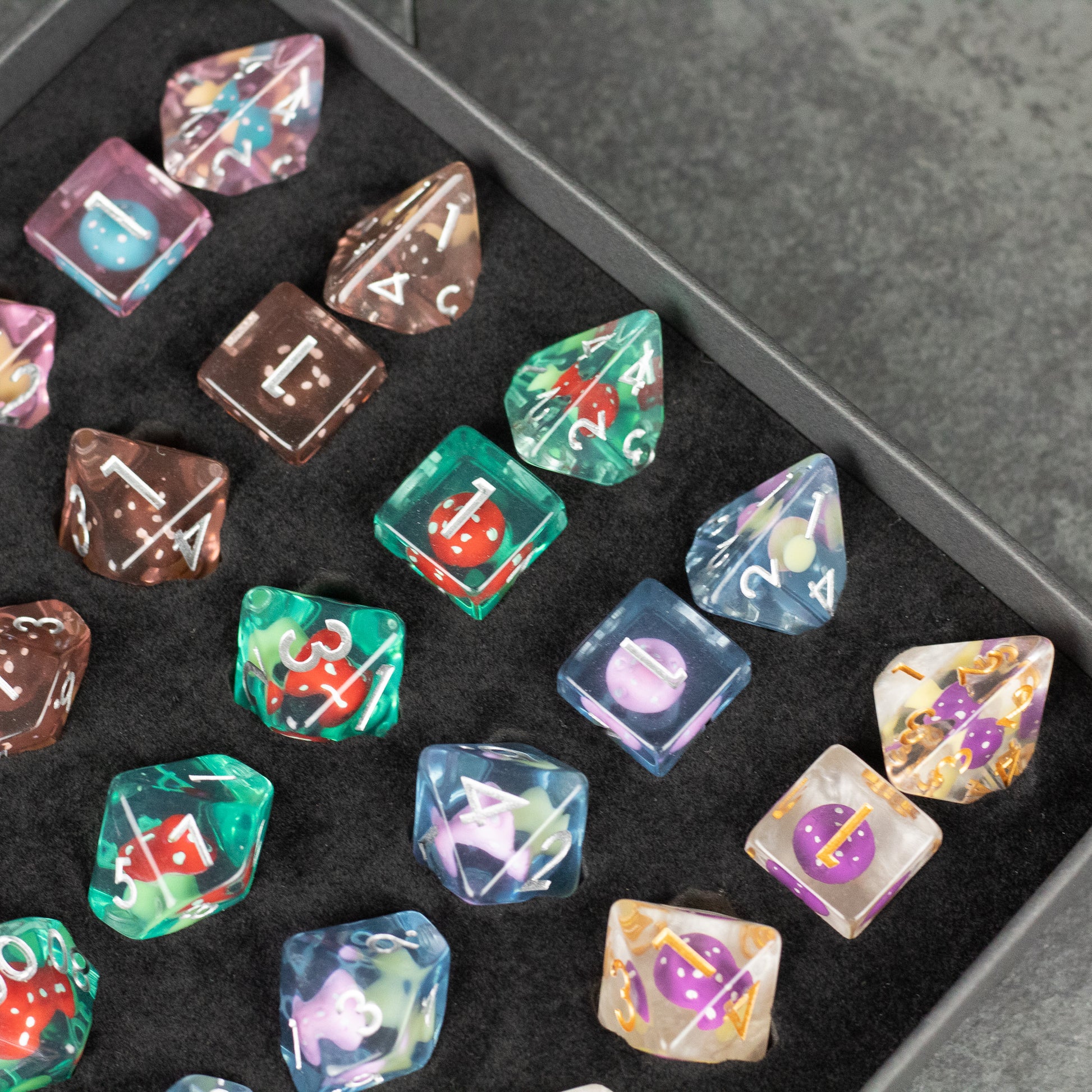 Mushroom Dice Set Gift Box - Colorful polyhedral dice set with mushroom-themed and celestial designs inside a black gift box.