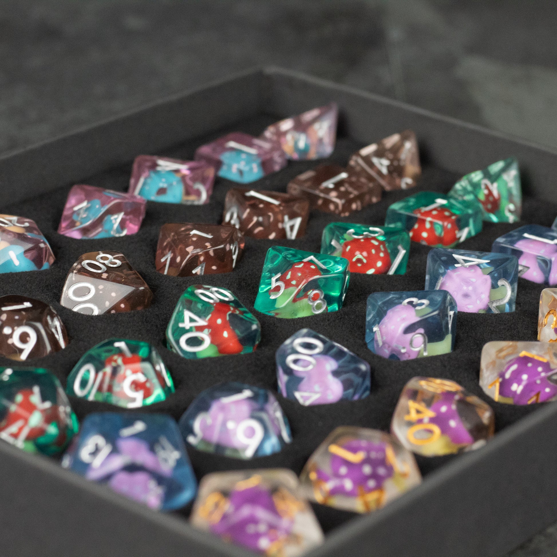 Mushroom Dice Set Gift Box - Colorful polyhedral dice set with mushroom designs, featuring shades of purple, green, brown, and blue, in a black gift box.
