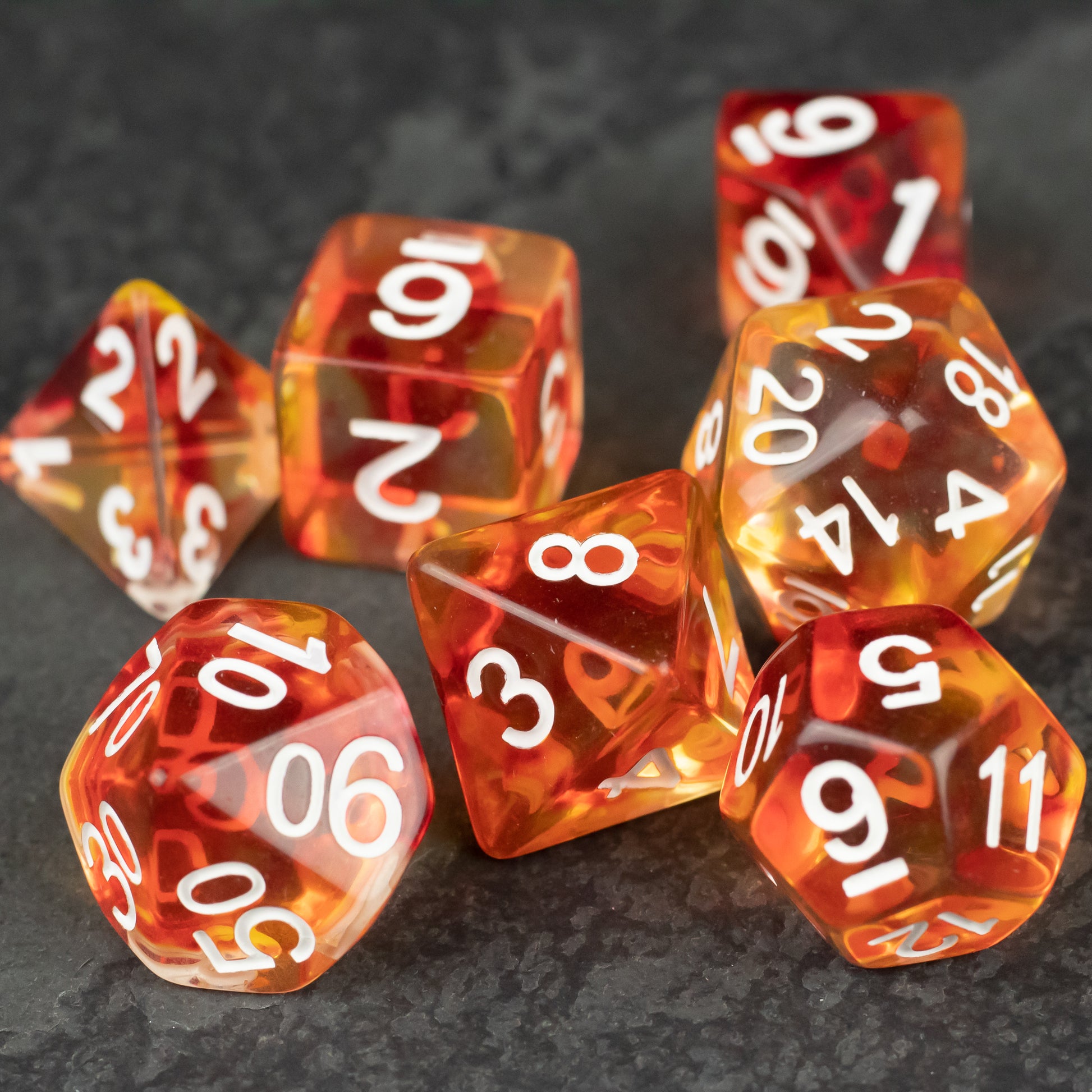 Magma Dice Set - Translucent orange and red polyhedral dice set with white numbers, including d4, d6, d8, d10, d12, and d20 shapes.