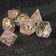 Polar Bear Dice Set - Translucent pink and white dice set with gold numbering and polar bear inside each die on dark textured surface.