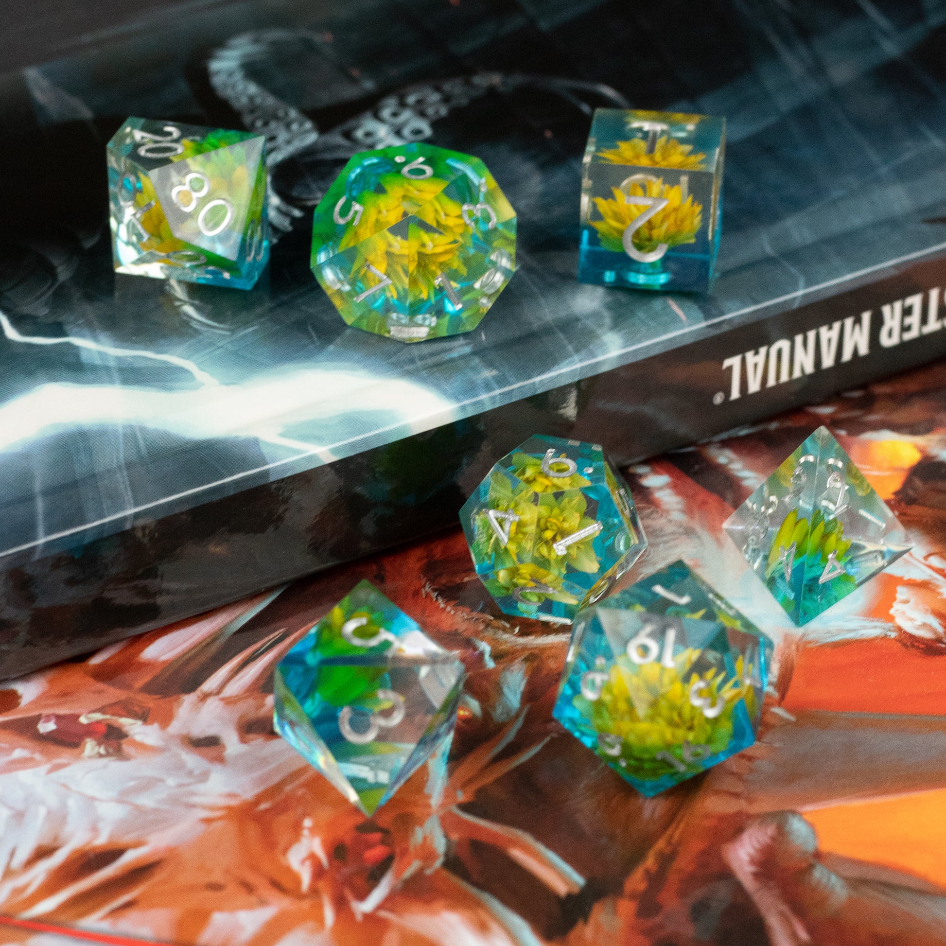 Yellow Flower + Blue Resin Sharp Edge Dice Set - Set of translucent blue resin dice with sharp edges, each containing embedded yellow flowers and white numbering.