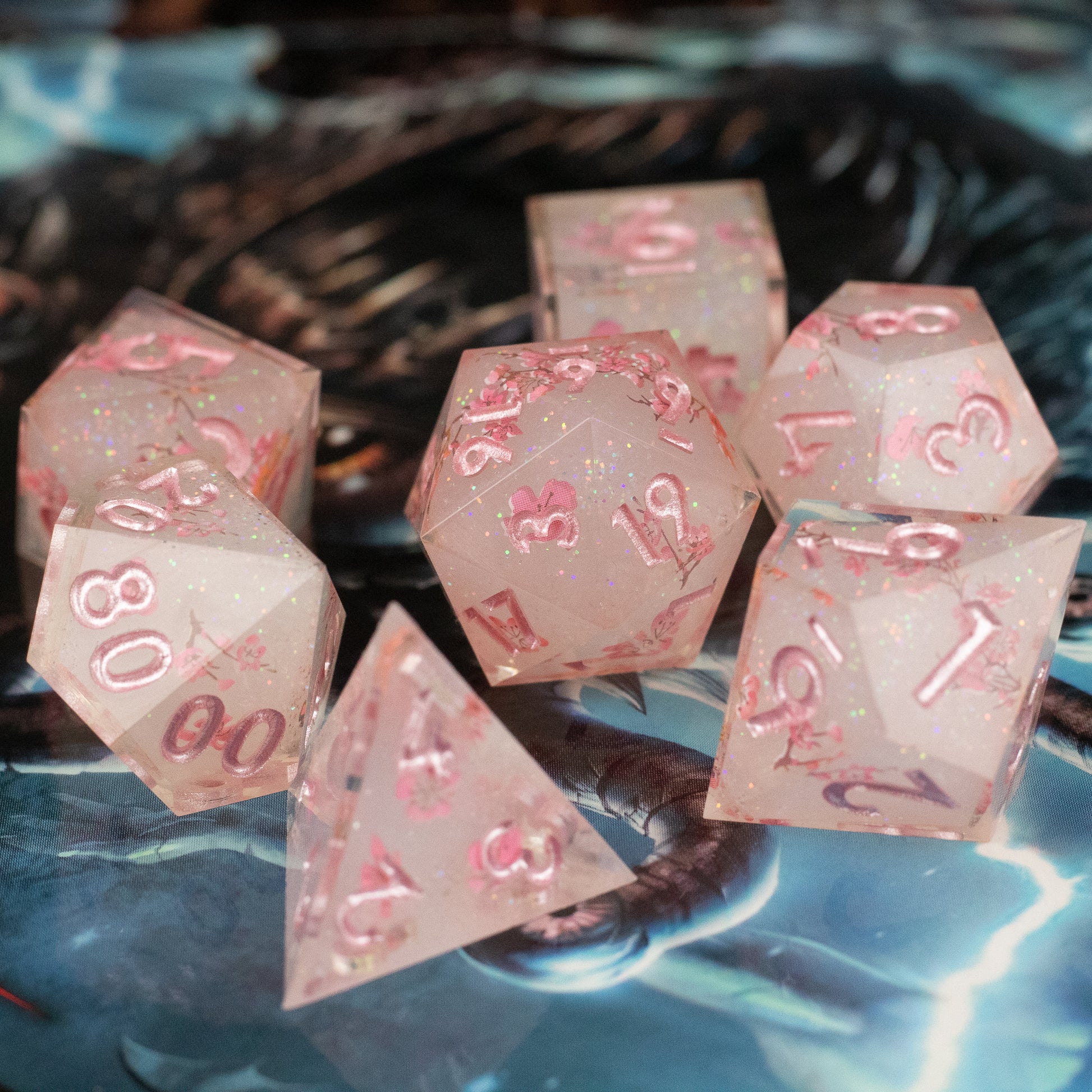 Pink Cherry Blossom Dice Set - Translucent pink polyhedral dice set with sharp edges and cherry blossom design details.